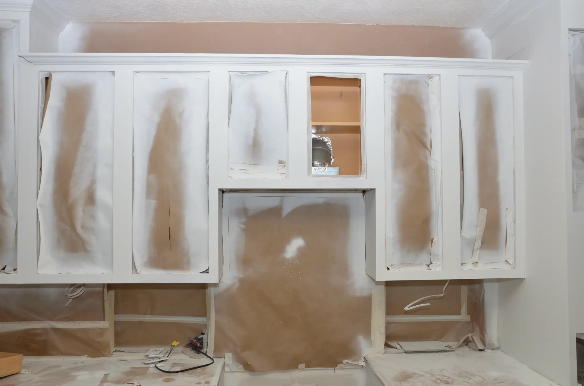 Kitchen cabinets masked and prepared for refinishing